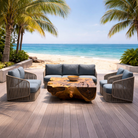 Outdoor patio set with a wooden table and chairs on a deck overlooking the ocean.