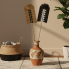 Two feather dusters, one beige and one black and white.
