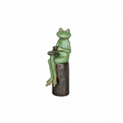 Frog statue with a cup on a stone in a pond with koi fish and lily pads.