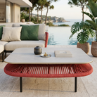 Outdoor patio setting with a modern sofa, coffee table.
