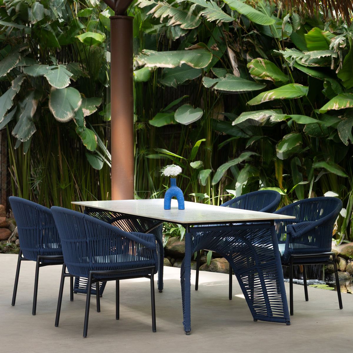 Outdoor dining set featuring a rectangular table and four contemporary woven dining chairs.